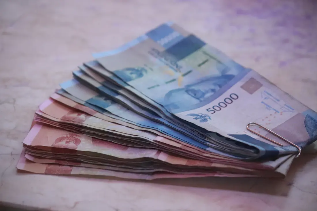 Fajo de billetes de pesos mexicanos sobre una mesa